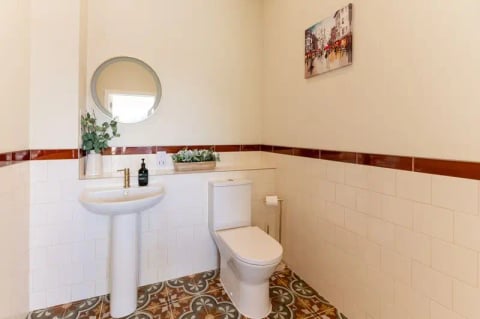 Cloakroom with round mirror and encaustic-tiled floor