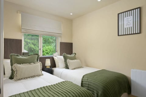 Twin bedroom with green runners and gingham cushions