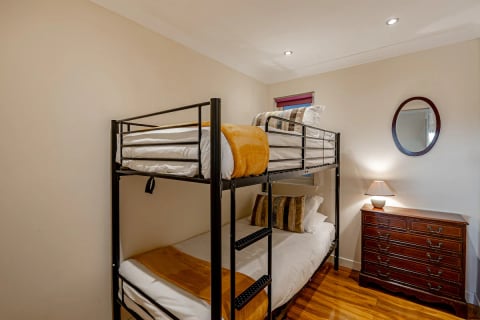 Black metal bunk beds with mustard throws
