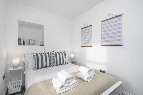 Guest bed with striped cushions and towels