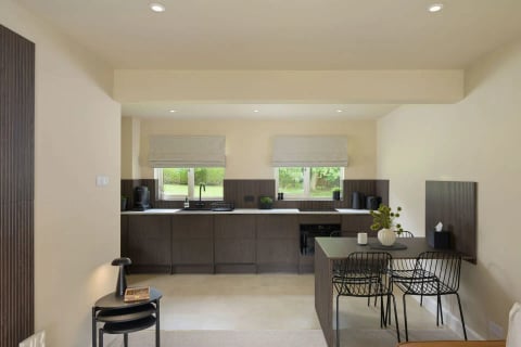 Kitchen with island, black stools and roman blinds