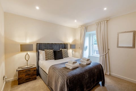 King bedroom with charcoal headboard and patterned cushions