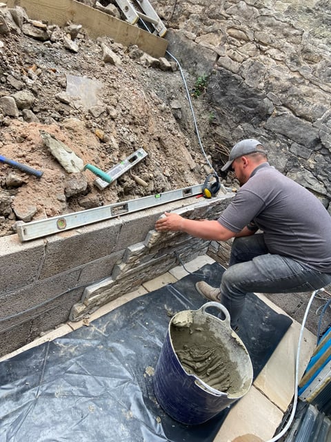 Hand-finishing a natural stone retaining wall