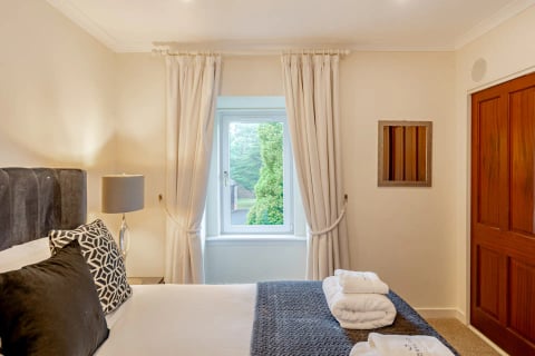 Bedroom window with cream curtains and lamp