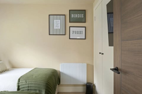 Guest bed with green throw and golf prints