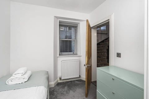 Single bedroom with mint dresser and day bed