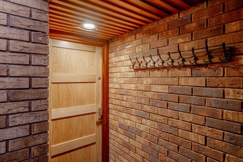 Oak apartment door in the brick-lined entrance