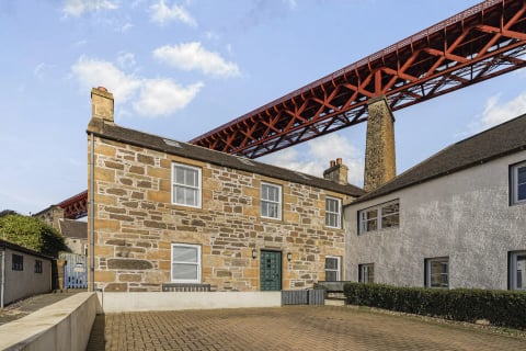 The house tucked beneath the great red bridge