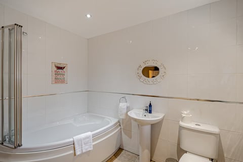 Corner jacuzzi bath with oval mirror
