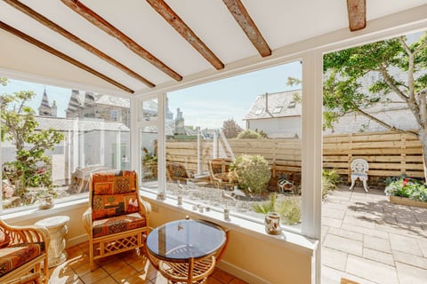 Garden room with rattan chairs looking onto the courtyard