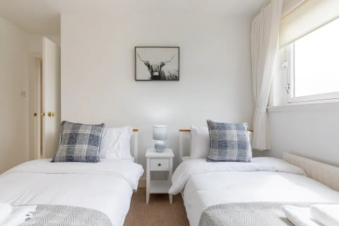 Twin bedroom with check cushions and bedside table