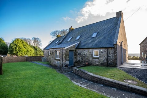 The long stone side of the cottage on the lawn