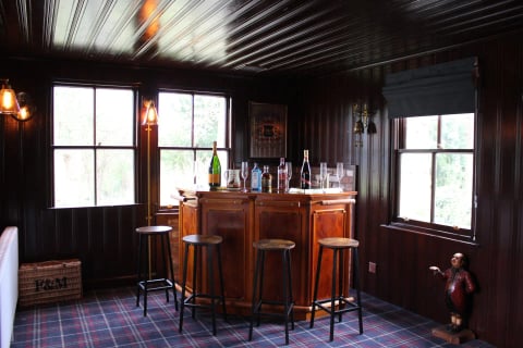 The panelled whisky bar with stools and tartan carpet