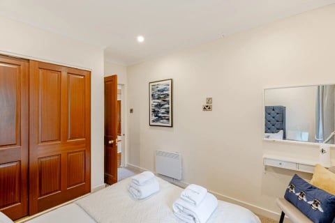 Double bedroom with artwork and warm oak doors