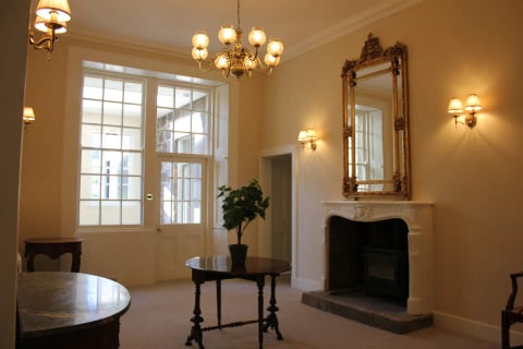 The morning room with gilt mirror and chandelier