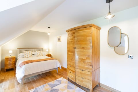Bedroom with oak wardrobe and patterned rug