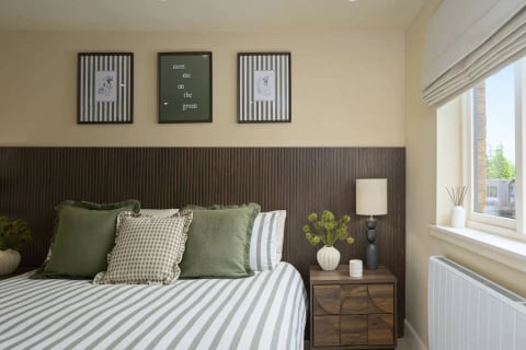Double bed with olive cushions and table lamp