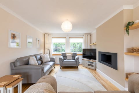 Lounge with grey leather sofas, TV and wall-mounted fire