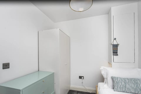Bedroom with white wardrobe and gold mirror light