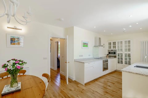 Hall into the white cottage kitchen with oak floors
