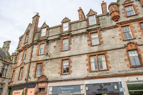 The red-sandstone tenement above the high street shops