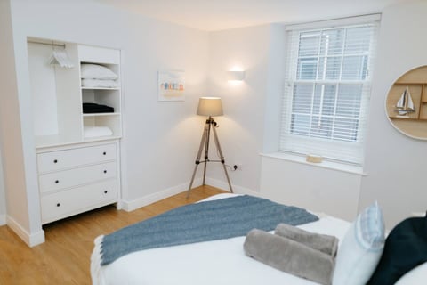Bedroom with tripod lamp and fresh linen