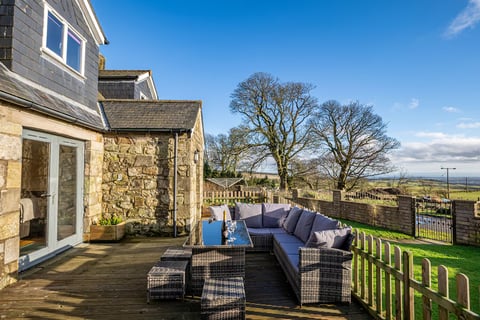 Decked terrace with outdoor sofa beside the gable