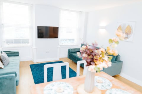 Teal sofa beneath the wall-mounted TV