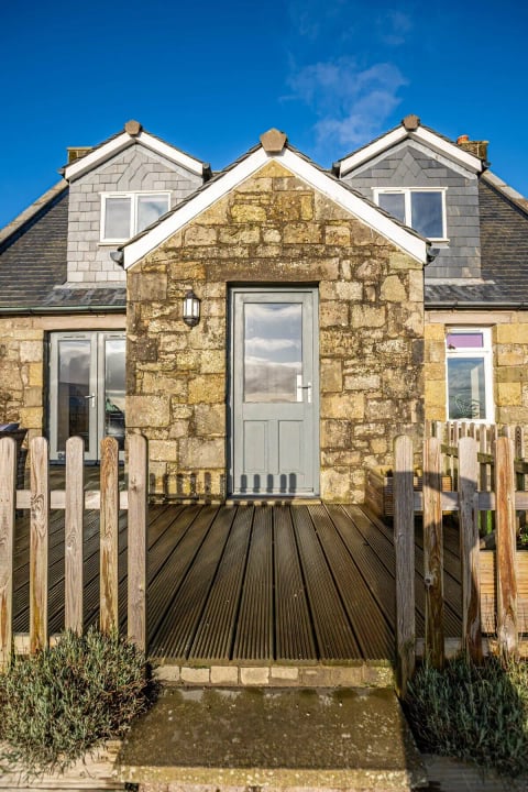 The grey front door onto the deck