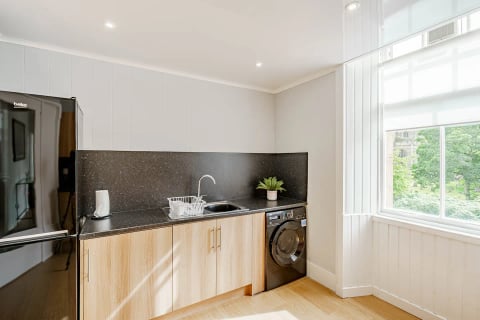 Kitchen with black worktops and washer-dryer