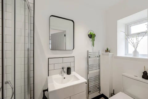 Cloakroom with square mirror and heated towel rail