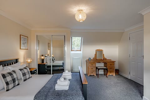 Bedroom with sliding mirror wardrobes and vanity