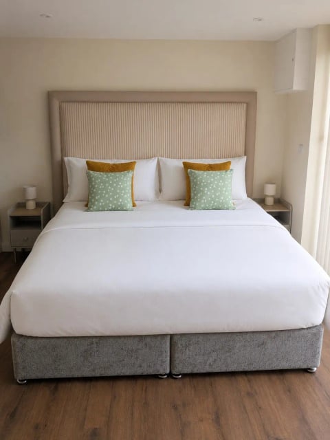 King bed with sage green cushions