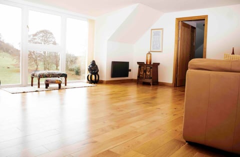 Open living space with oak floor and valley views