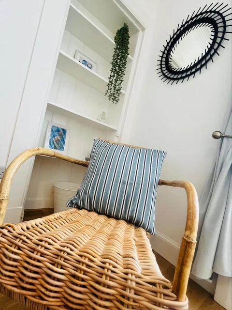 Rattan chair in a bright corner with striped cushion