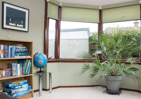 Bay-window reading corner with bookshelf and globe