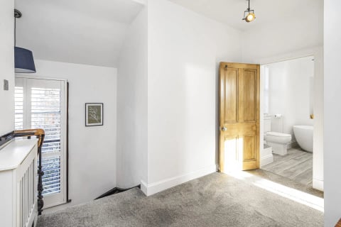 Landing with oak door and carpeted stairs