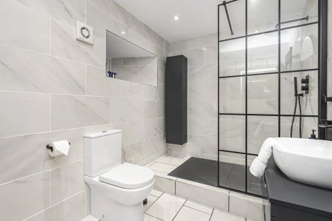 Marble-tiled shower room with black-framed screen