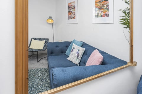 The sofa reflected in the wooden mirror