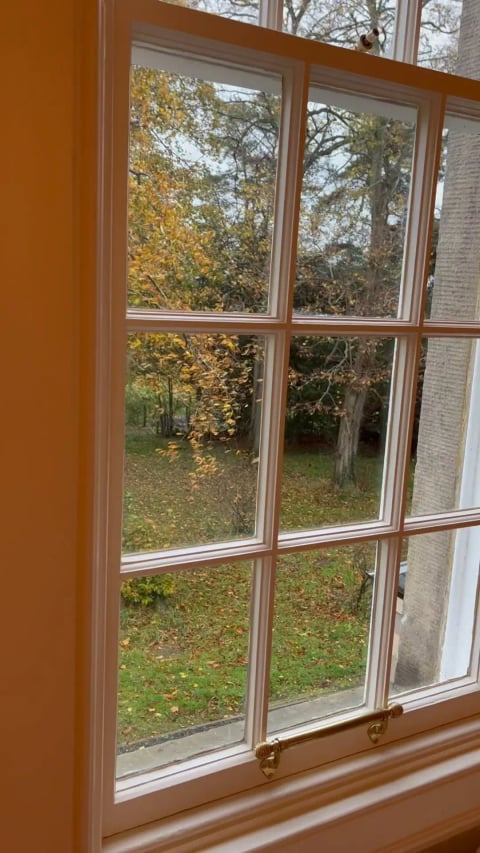 Autumn trees reflected in the sash window