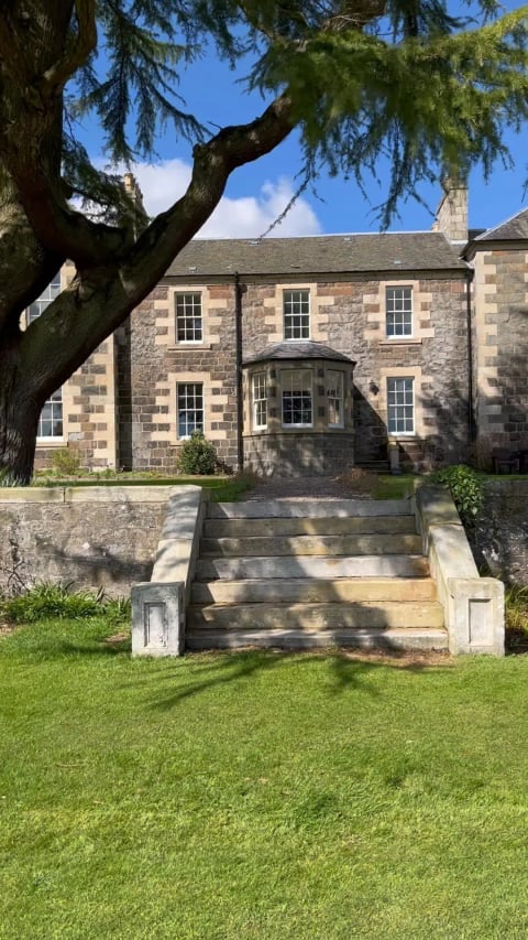 Stone steps up to the lawn and bay window