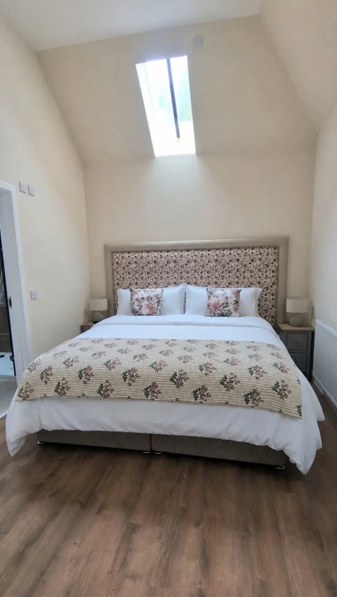 King bedroom with floral upholstered headboard