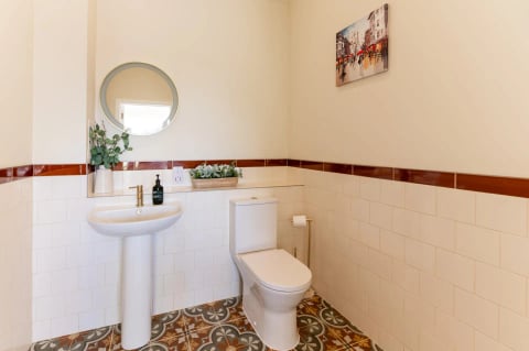 Cloakroom with round mirror and patterned floor