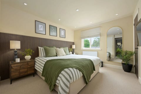 King bedroom with striped bedding and arched mirror