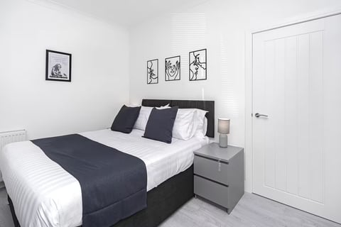 Double bedroom with black headboard and bedside lamp