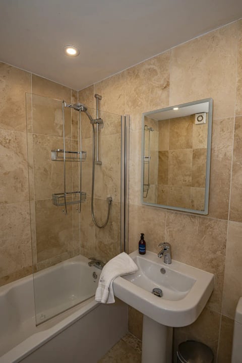 Bathroom with shower over the bath and mirror cabinet