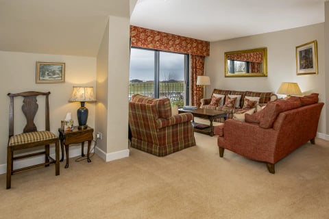 Sitting area with tartan armchairs and balcony view