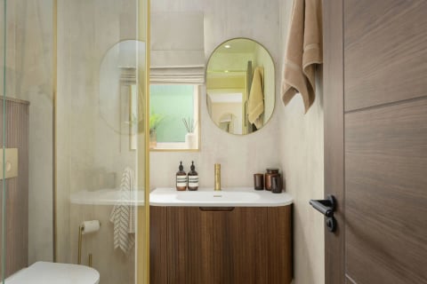 En-suite with oval mirror and gold fittings