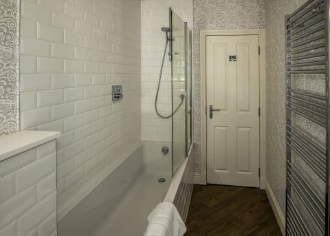 Bathroom with over-bath shower and metro tiling