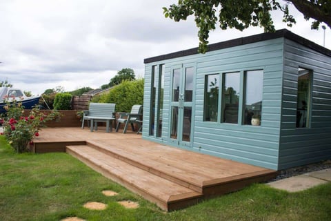 The blue summerhouse on its decked terrace